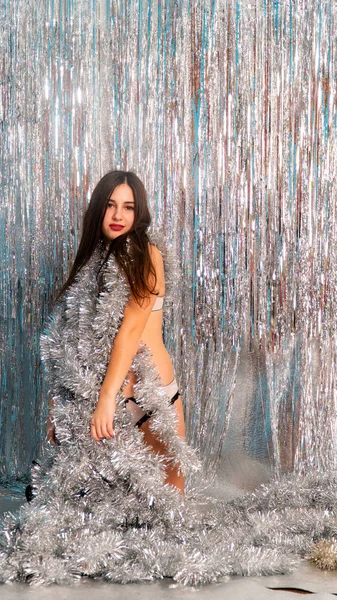 Stüdyoda poz veren parlak noel süsleriyle güzel seksi kadın, tatil konsepti.   