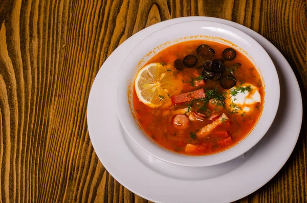 Borsch ucraniano tradicional com nata azeda e feijão branco em um fundo escuro. Sopa de beterraba vegetal vermelha. — Fotografia de Stock