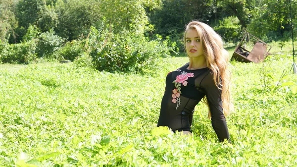 Portrait d'une jeune femme blonde souriante allongée sur de l'herbe verte . — Photo