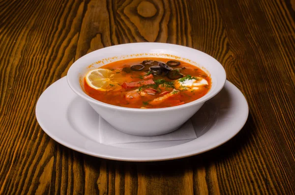 Borsch ucraniano tradicional com nata azeda e feijão branco em um fundo escuro. Sopa de beterraba vegetal vermelha. — Fotografia de Stock