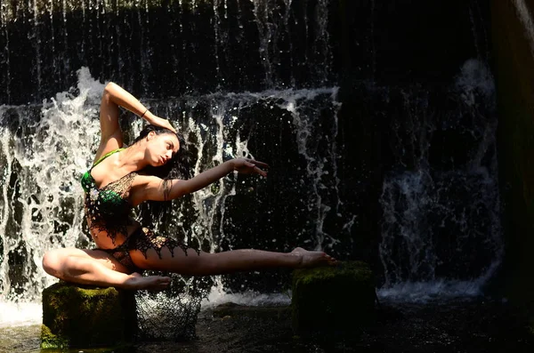 Jonge brunette model poseren tegen een waterval — Stockfoto