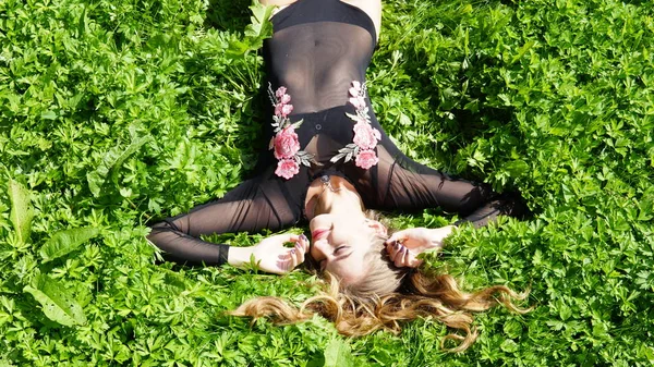 Mooie jonge vrouw ligt op het gras. Verse natuurlijke zomer concept. Uitzicht vanaf de top. — Stockfoto