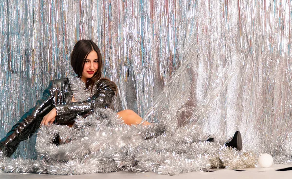 Stüdyoda poz veren parlak noel süsleriyle güzel seksi kadın, tatil konsepti.   