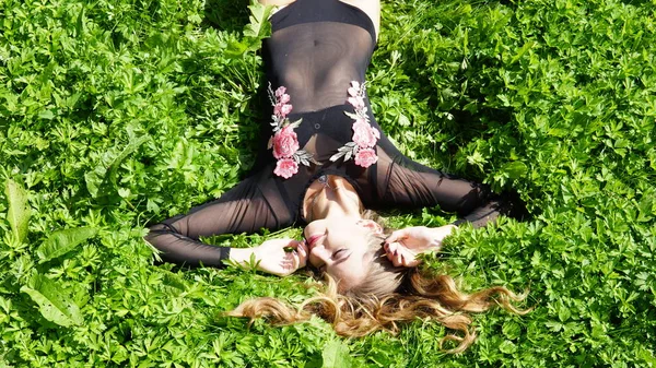 Mooie jonge vrouw ligt op het gras. Verse natuurlijke zomer concept. Uitzicht vanaf de top. — Stockfoto