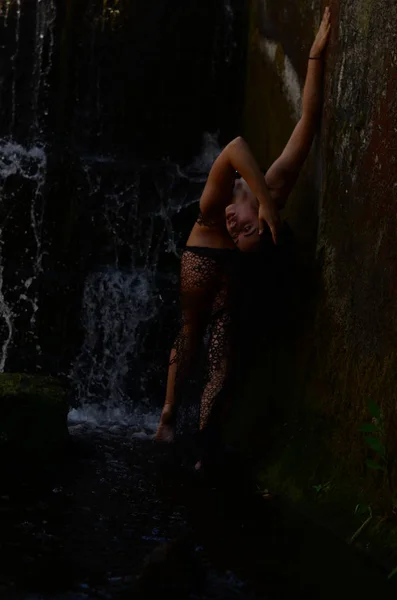 Joven modelo morena posando contra una cascada — Foto de Stock