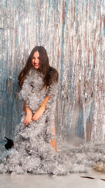 Stüdyoda poz veren parlak noel süsleriyle güzel seksi kadın, tatil konsepti.   