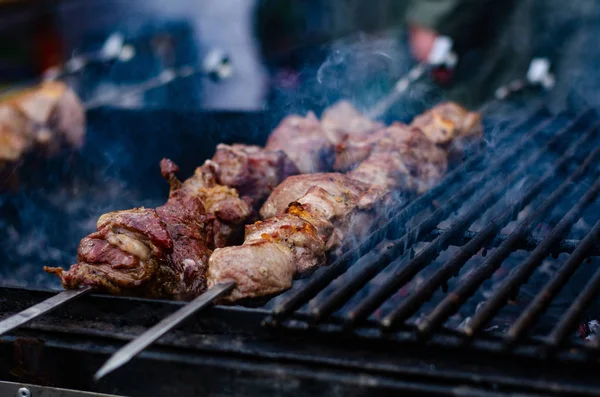 Close-up de alguns espetos de carne sendo grelhados em um churrasco — Fotografia de Stock