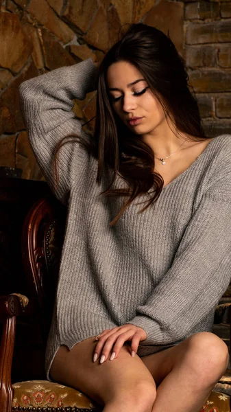 Hermosa chica sexy, con un vestido gris corto, una chimenea. —  Fotos de Stock