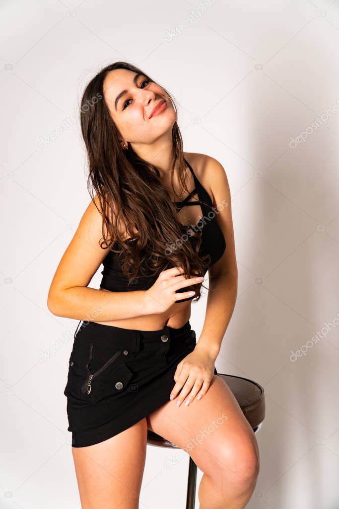 Portrait of disconcerted young woman in light clothes looking aside covering nose with hand isolated on white wall background in studio. People sincere emotions, lifestyle concept. Mock up copy space