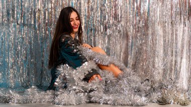 Stüdyoda poz veren parlak noel süsleriyle güzel seksi kadın, tatil konsepti.   