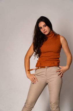 Güzel esmer model, karanlık odada poz veriyor. 