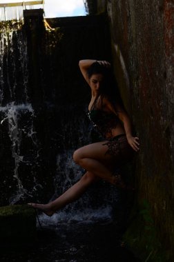 Genç esmer model bir şelale karşı poz