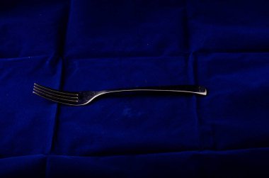 Tekstil arka planına karşı gümüş metal çatal 