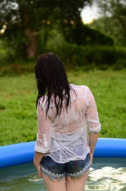 Gün batımında, havuzda ıslak güzel bir kız bedeni.