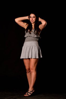 Seksi, güzel, esmer, esmer bir kadın. Kıyafet şortu ve ceket makyajı giyiyor. Ofis tarzı şık bir iş kadını. Resmi elbise. Dalgalı saçlı, çekici bir kız.