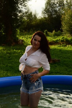 Gün batımında, havuzda ıslak güzel bir kız bedeni..