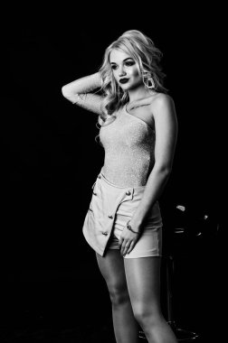 Güzel, şık, sarışın, makyajlı, siyah arka planda saç kesimi olan bir kadın.  