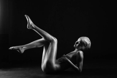 Gümüş rengi vücut boyalı genç atletik kadın.