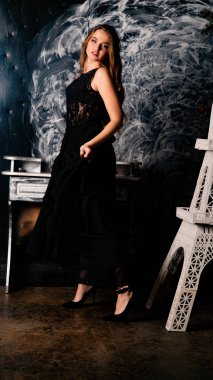 Stüdyoda dantel elbiseyle poz veren genç ve güzel bayan.  