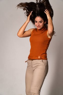 Güzel esmer model, karanlık odada poz veriyor. 