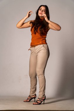 Güzel esmer model, karanlık odada poz veriyor. 