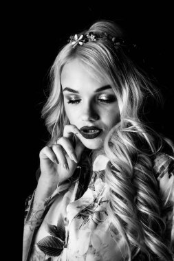 Güzel, şık, sarışın, makyajlı, siyah arka planda saç kesimi olan bir kadın.  