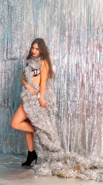 Stüdyoda poz veren parlak noel süsleriyle güzel seksi kadın, tatil konsepti.   