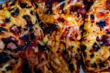 Mozzarella peynirli, jambonlu, domates soslu, salamlı, biberli, baharatlı ve taze roka soslu pizza. İtalyan pizzası ahşap masa arkasında