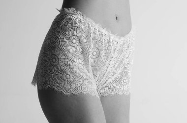 Beyaz iç çamaşırlı seksi kız stüdyoda poz veriyor.