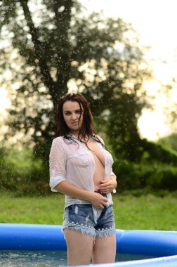 Gün batımında, havuzda ıslak güzel bir kız bedeni..