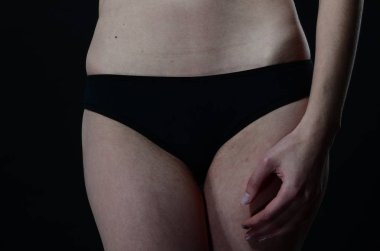 Sarı ceketli, şortlu ve topuklu ayakkabılı zarif bir kadın. Moda stüdyosu çekimi.