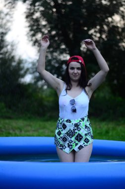 Gün batımında, havuzda ıslak güzel bir kız bedeni..