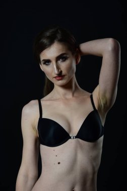 Sarı ceketli, şortlu ve topuklu ayakkabılı zarif bir kadın. Moda stüdyosu çekimi.