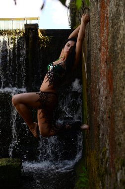 Genç esmer model bir şelale karşı poz