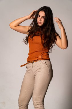 Güzel esmer model, karanlık odada poz veriyor. 