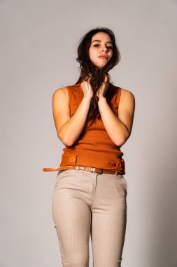 Güzel esmer model, karanlık odada poz veriyor. 