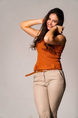 Güzel esmer model, karanlık odada poz veriyor. 