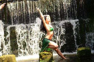 Genç esmer model bir şelale karşı poz