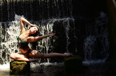 Genç esmer model bir şelale karşı poz