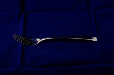 Tekstil arka planına karşı gümüş metal çatal 