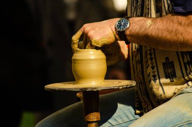 Bir çömlekçinin elleri kilden bir kap yapıyor.. 