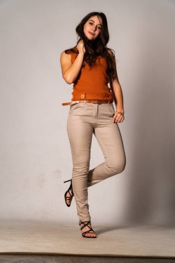 Güzel esmer model, karanlık odada poz veriyor. 