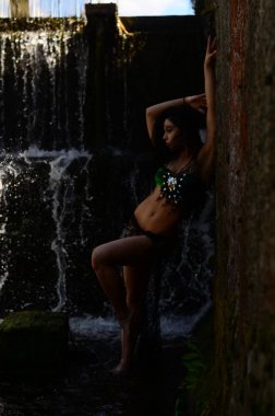 Genç esmer model bir şelale karşı poz