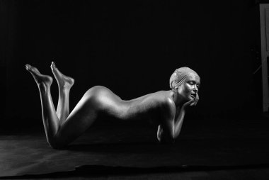 Gümüş rengi vücut boyalı genç atletik kadın.