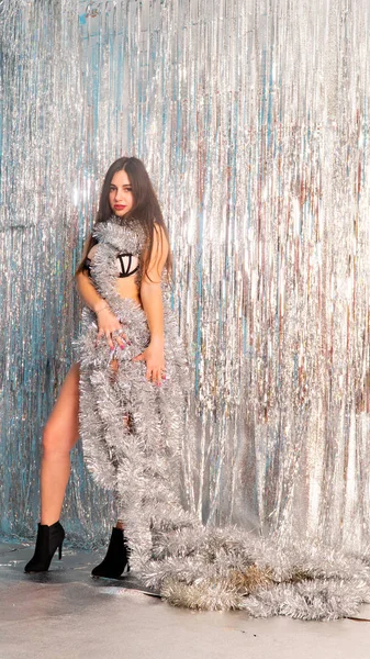 Stüdyoda poz veren parlak noel süsleriyle güzel seksi kadın, tatil konsepti.   