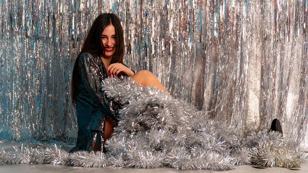 Stüdyoda poz veren parlak noel süsleriyle güzel seksi kadın, tatil konsepti.   