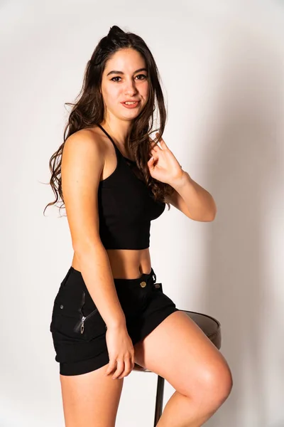 Retrato de la mujer joven desconcertada con ropa ligera mirando a un lado cubriendo la nariz con la mano aislada sobre fondo de pared blanca en estudio. Gente sincera emociones, concepto de estilo de vida. Almacenamiento del espacio de copia —  Fotos de Stock