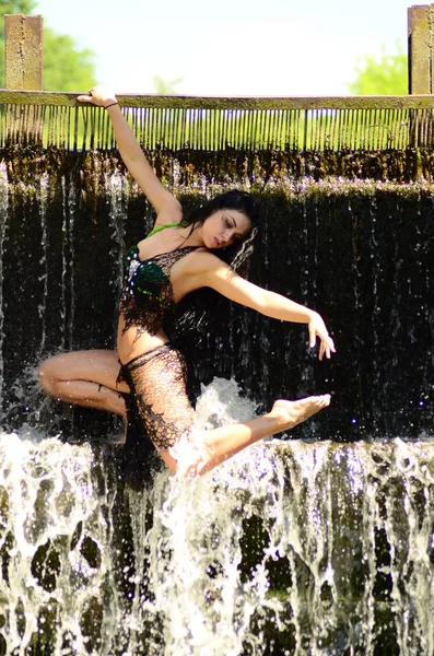Giovane modella bruna posa contro una cascata — Foto Stock