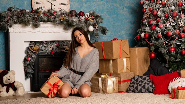 크리스마스 스튜디오의 벽난로 근처에 포즈를 취하고 스웨터를 아름다운 — 스톡 사진