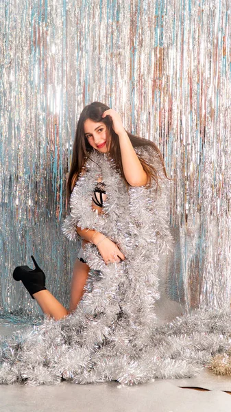 Stüdyoda poz veren parlak noel süsleriyle güzel seksi kadın, tatil konsepti.   